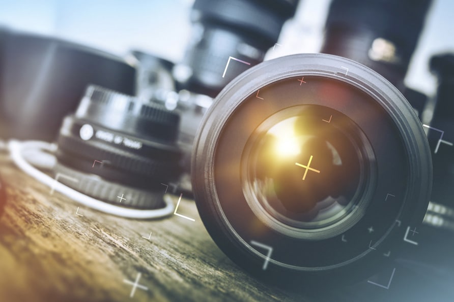 Looking into a camera lens with blurred out camera lenses in the background.